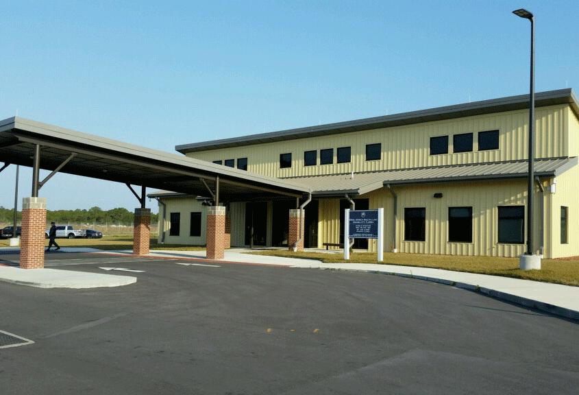 Two-story Naval Branch Clinic with yellow walls and a metal roof.